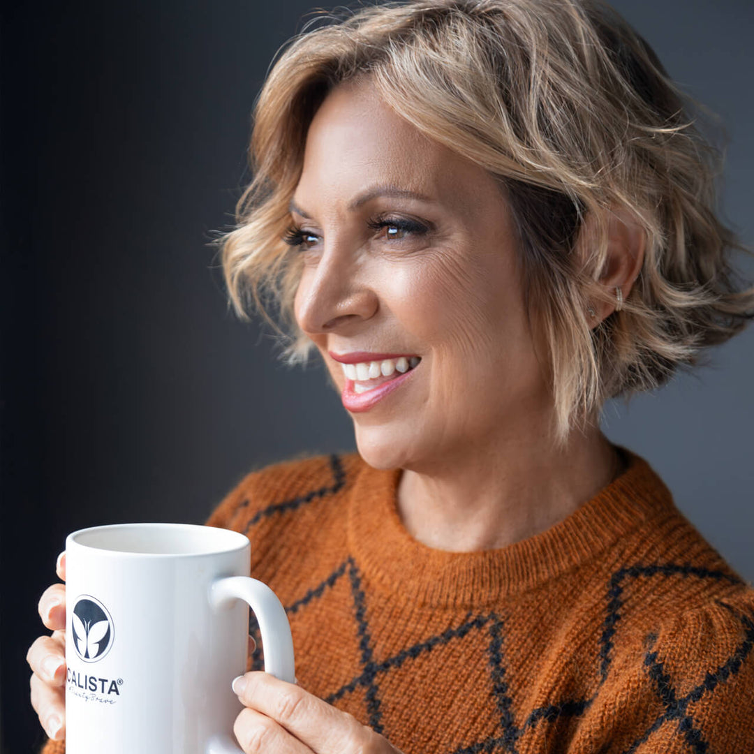 Maria McCool holding a coffee mug and smiling