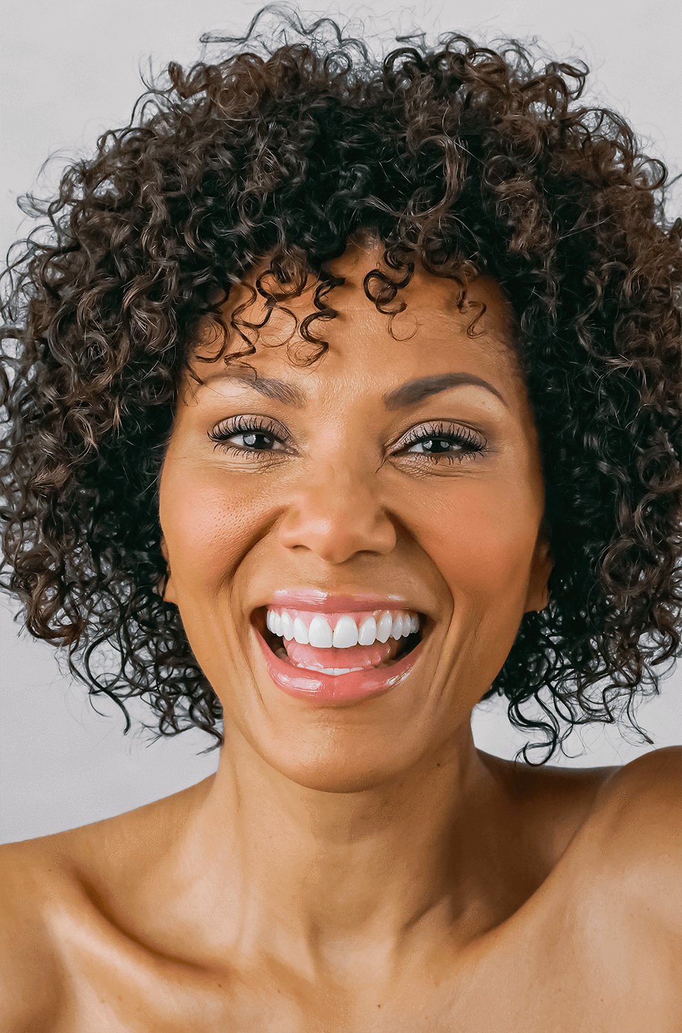 woman with defined curly hair smiling