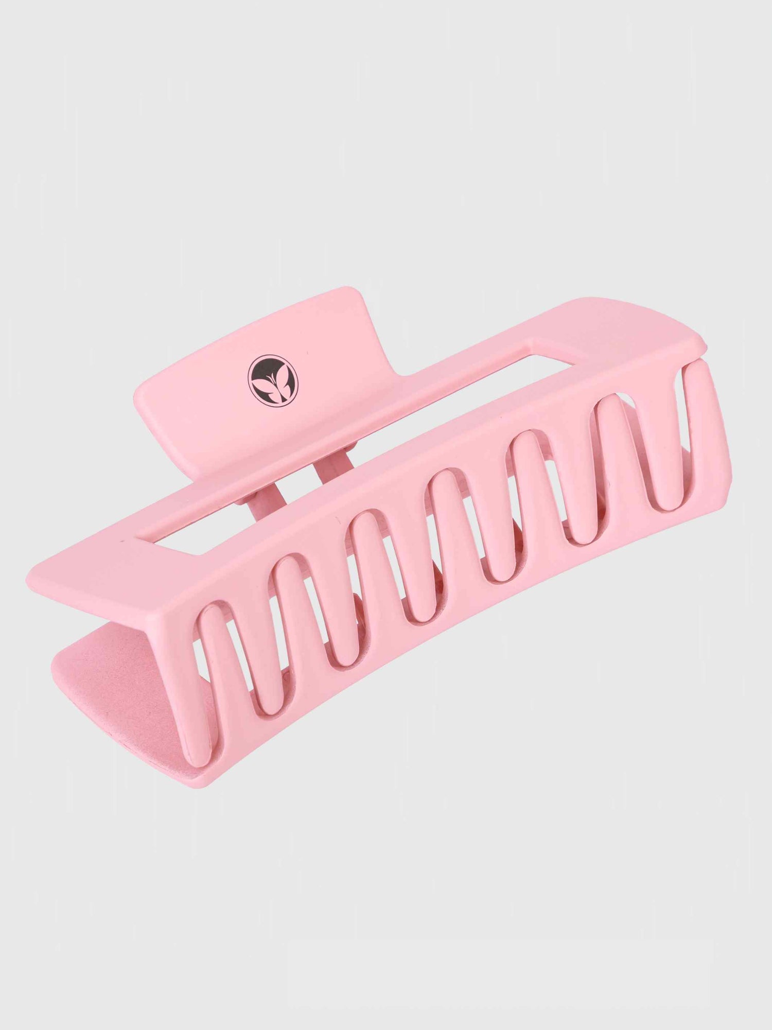 The Calista Claw Clip by Calista Tools is a large, light pink matte hair clip with wide, evenly spaced teeth and a rectangular shape. It features a small circular logo on the hinge and is shown against a plain light background.