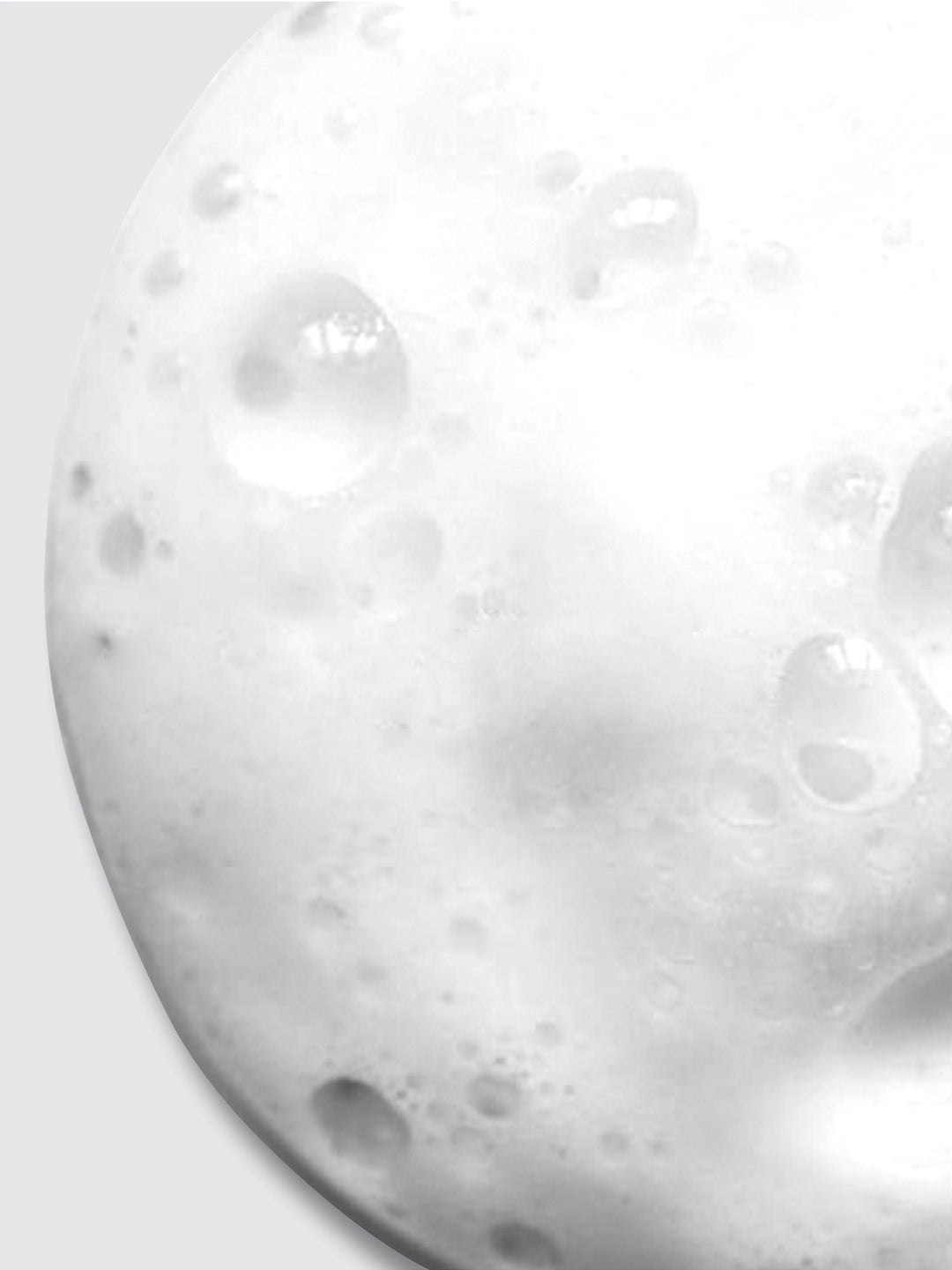 Close-up of white, foamy bubbles clustered together, resembling soap lather or foam on a smooth surface, with various sizes of bubbles creating a textured appearance.