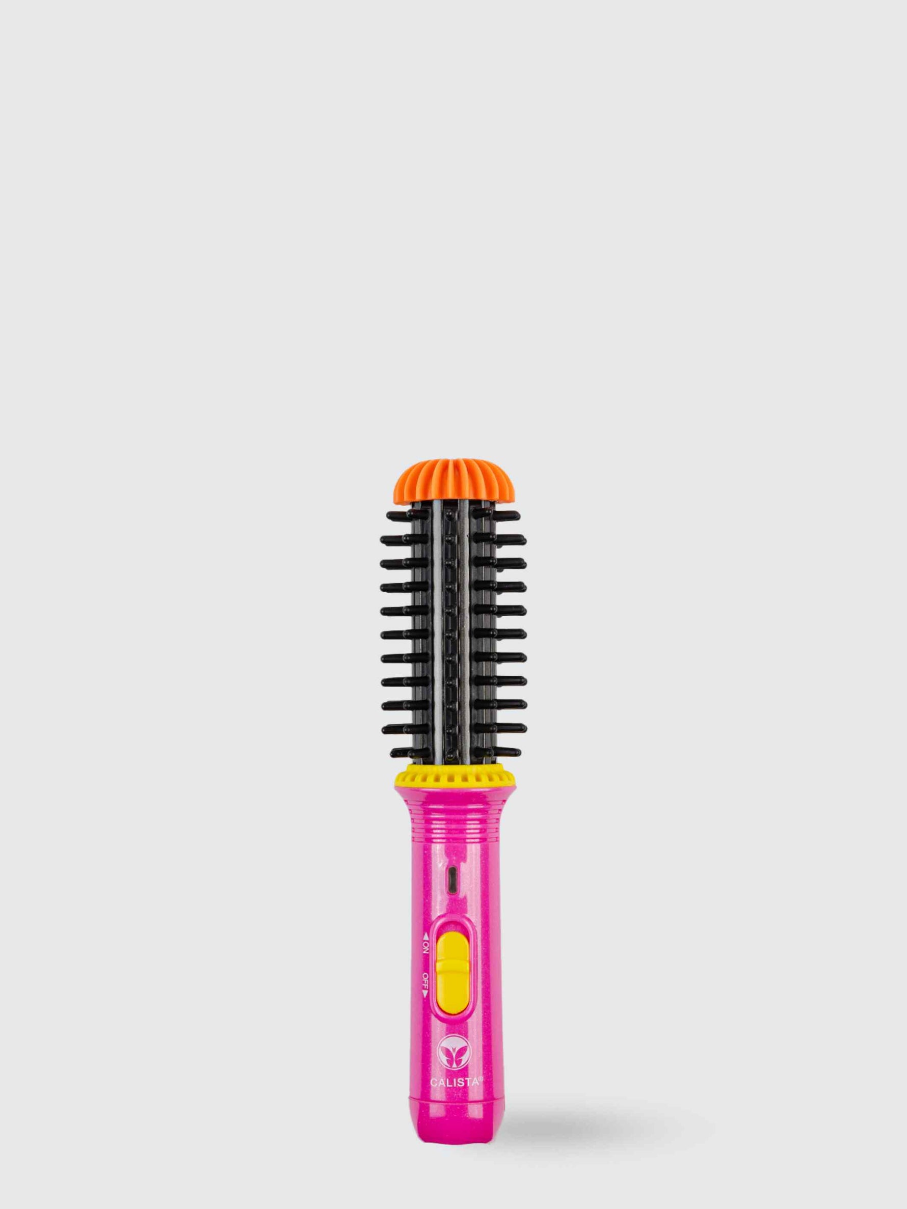 The Refurbished GoGo Mini Round Brush by Calista Tools, featuring pink and yellow accents with black bristles and an orange tip, stands upright against a plain light gray background, ready to de-frizz and volumize hair.