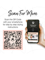 A hand holds a smartphone showing the Perfecter Pro Long Hair Duo virtual stylist page. To the left, a black and pink QR code appears above text: Scan for step-by-step heated styling tool instructions.