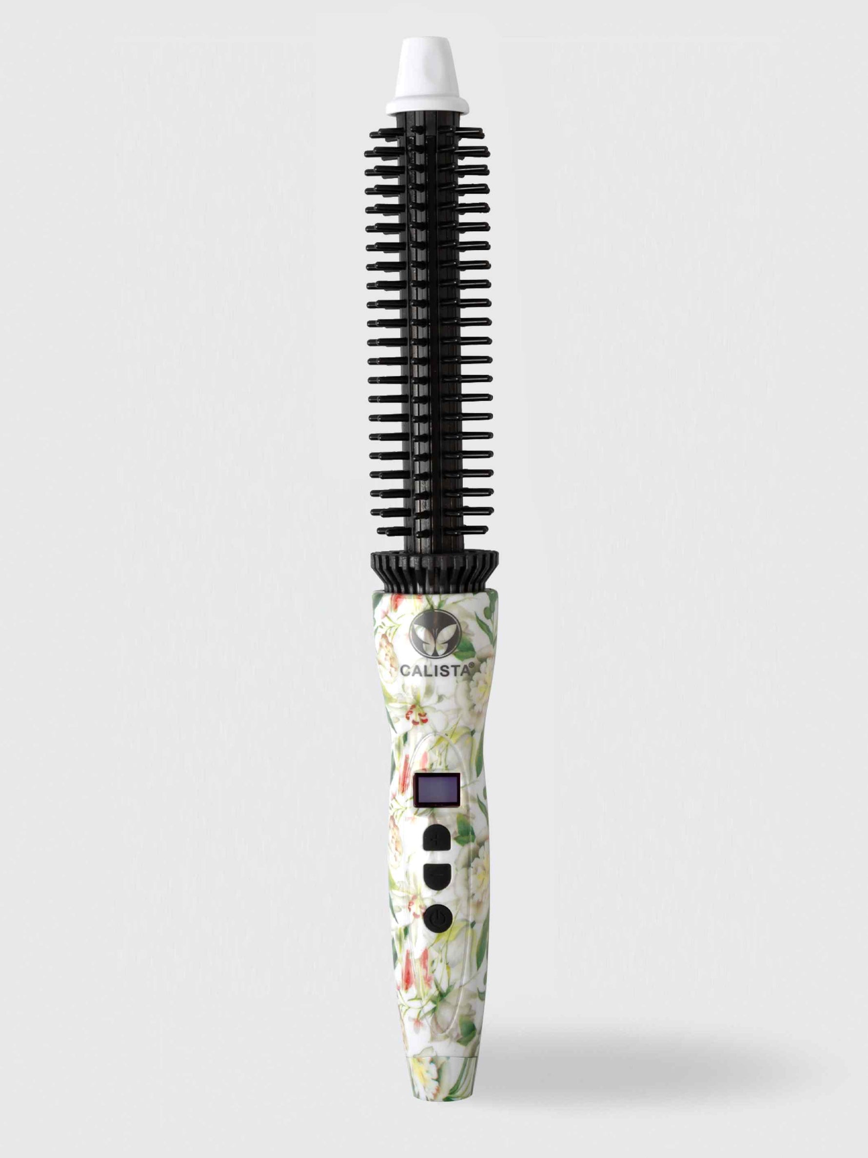 The Refurbished Perfecter Pro Heated Round Brush by Calista Tools, featuring a floral pattern, cylindrical barrel, black bristles, digital display, and white tip, stands upright against a light gray background—a chic styling tool.