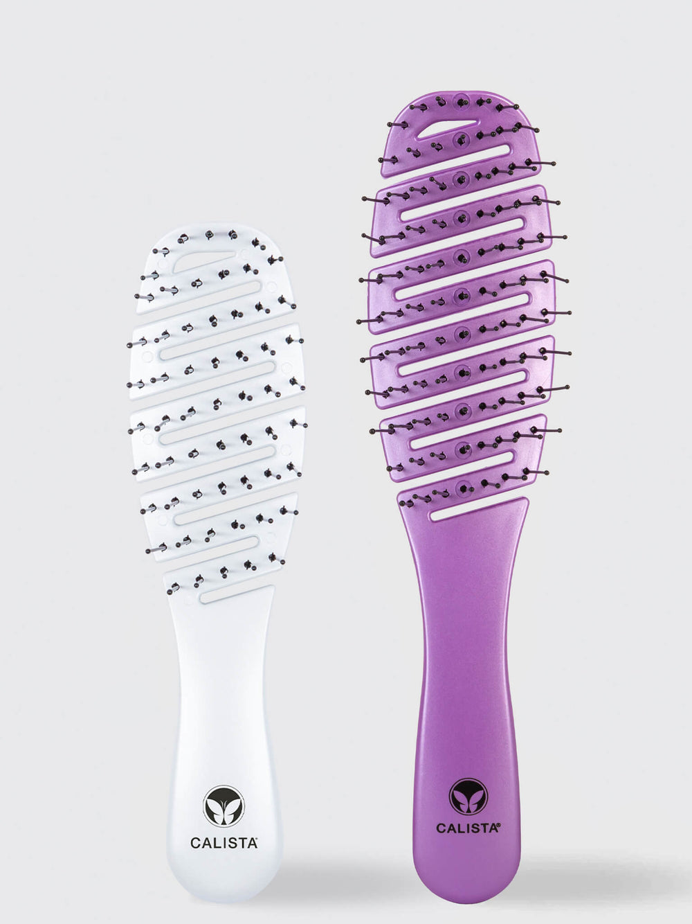 Two vented styling brushes from Calista Tools’ SMOOTHIE Original + Mini Duo stand upright on a light background—one white, one purple. Both detangling brushes feature the “Calista” logo on the handle.